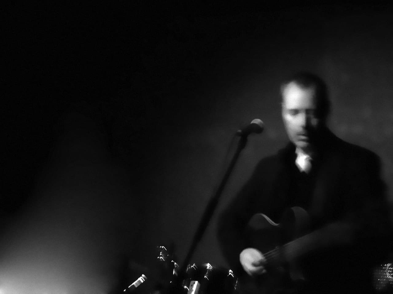 Background image of Hugh Featherstone on stage.